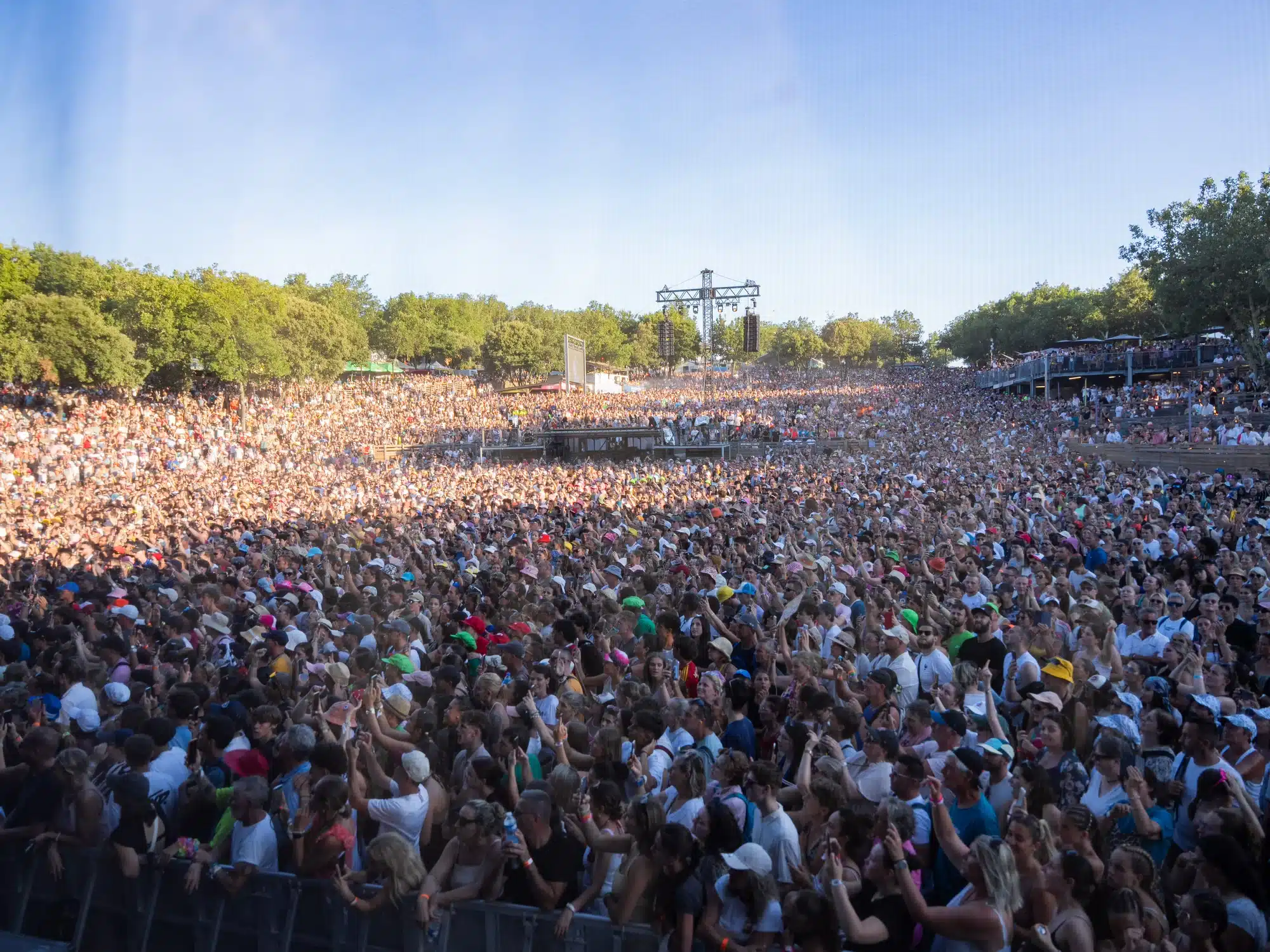 Vue aérienne d'une immense foule de festivaliers lors d'un concert en plein air.