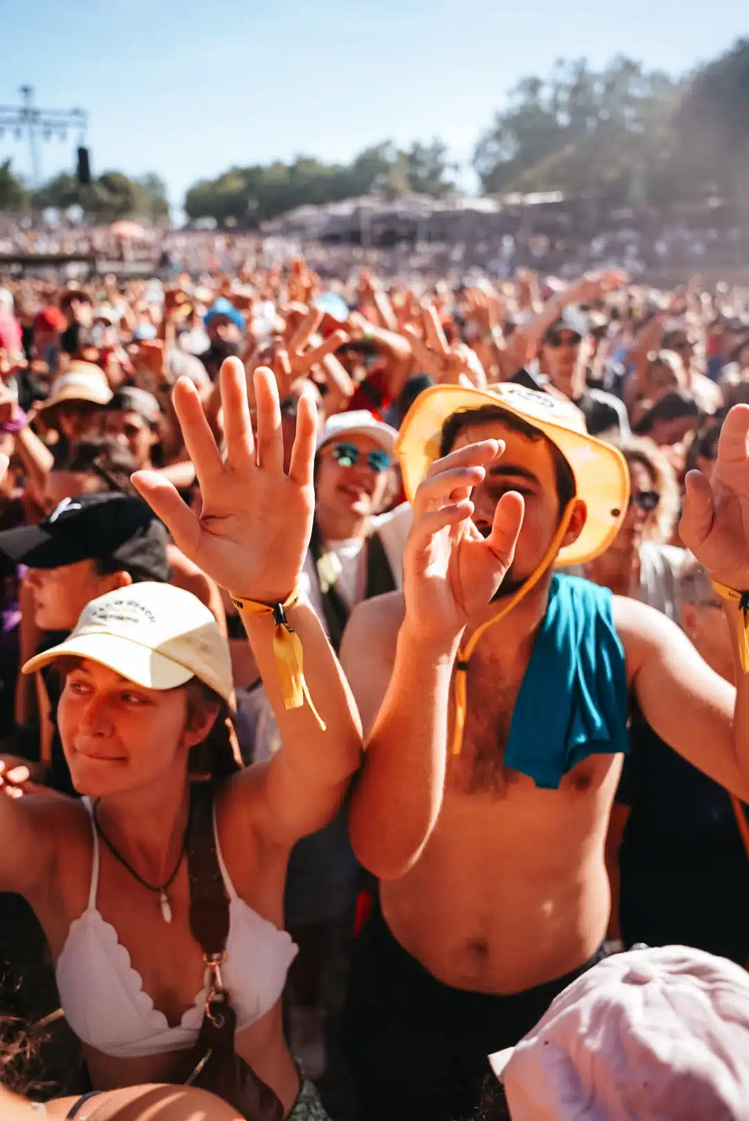 Foule en extase dans un festival en plein air sous un soleil radieux.