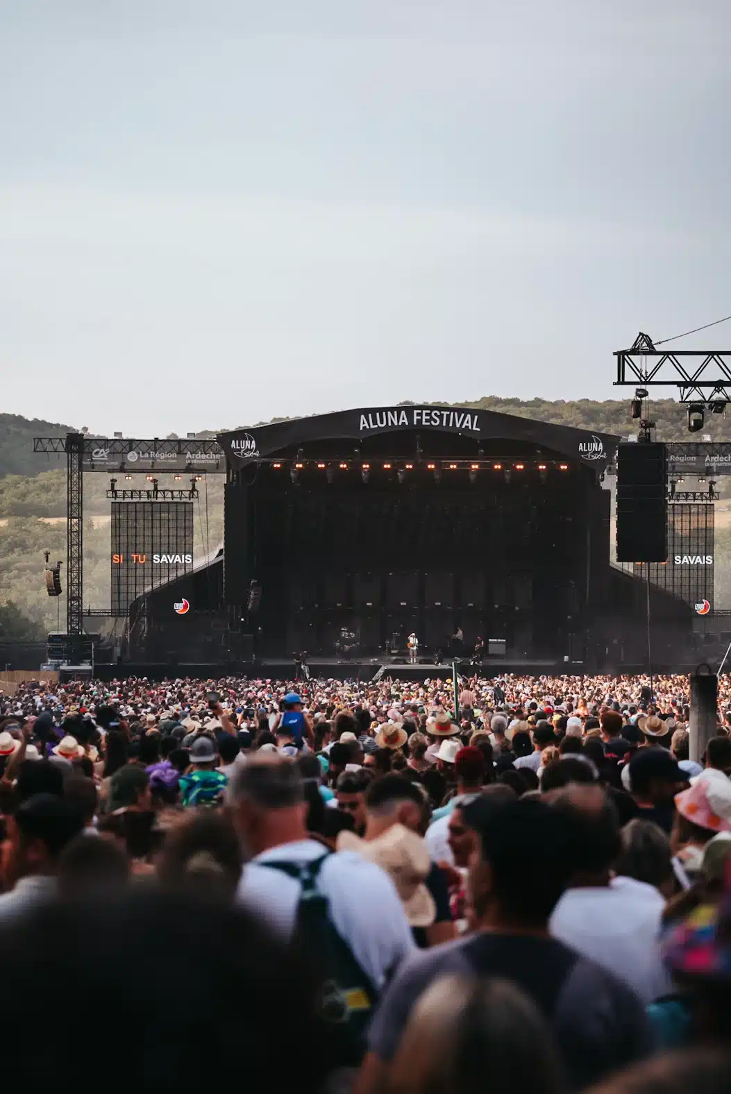 Une scène de festival de musique avec de nombreux spectateurs debout devant.